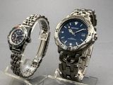 two watches that are on display on a clear stand