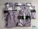 plusieurs paires de pantalons violets posées sur une table blanche