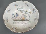 a white bowl with a painting on it on a table