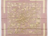 un foulard en soie rose et or représentant un oiseau perché sur une branche
