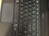 a black laptop with a black keyboard on a wooden table