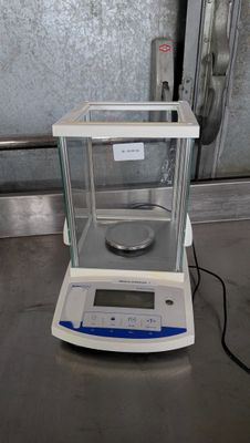 an electronic scale sitting on top of a metal counter top