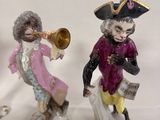 three figurines of a man and a woman playing musical instruments