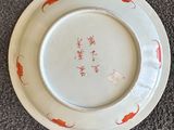 une assiette blanche ornée d'un poisson rouge