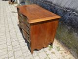 une commode en bois posée sur le trottoir