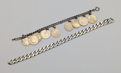 a silver bracelet with five coins and a chain