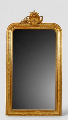 un miroir à cadre doré posé sur un mur blanc