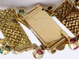 a gold plated bracelet with a gold plated watch on it