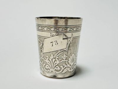 a silver cup with a number on it sitting on a table