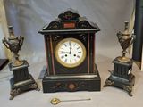 a small clock sitting on a table next to other items