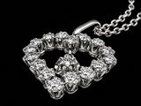 a heart shaped diamond pendant on a chain on a black background