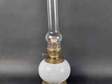 une lampe à huile à l'ancienne, surmontée d'un abat-jour en verre