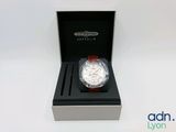 a close up of a watch in a box on a white surface