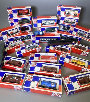 Plusieurs boîtes de trains miniatures sont empilées les unes sur les autres