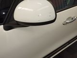 a side view mirror of a white car with black trims