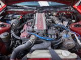 a red car with a red engine in the trunk of it