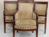 two wooden chairs with striped upholstered seats against a white wall