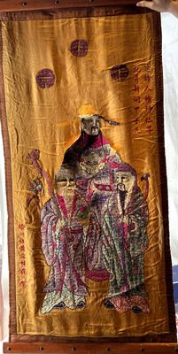 a person holding a large embroidered cloth with a picture on it