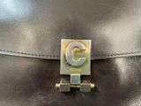 a close up of a black purse with a metal clasp