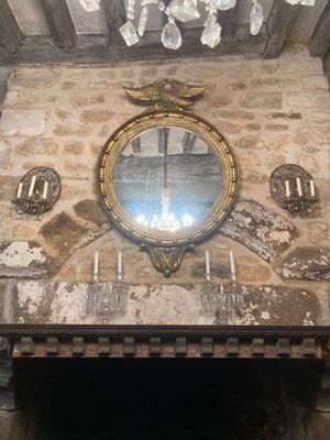 un miroir accroché au mur au-dessus de la cheminée d'une pièce