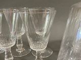 four wine glasses and a decanter on a table