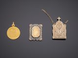 three gold and silver items including a cross, a plaque, and a coin