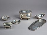 several pieces of silverware are arranged on a gray surface