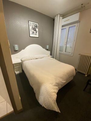 a white bed sitting in a bedroom next to a radiator