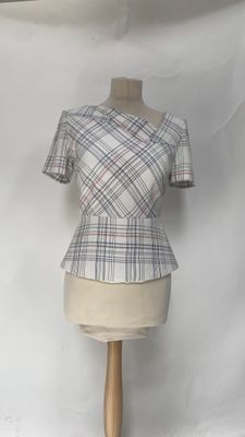 mannequin with a plaid top on a mannequin stand