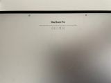 the back of a silver laptop computer sitting on top of a white table