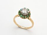 un gros plan d'une bague en or sertie d'un diamant et d'émeraudes