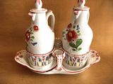 two white vases with red flowers on them sitting on a tray