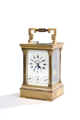 une horloge en or posée sur une surface blanche