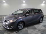 Une Toyota Sienna grise est garée sur un sol en carrelage à damier.