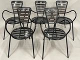 quatre chaises en métal noir posées sur une surface blanche