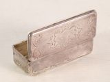 a small silver box with a flower design on it