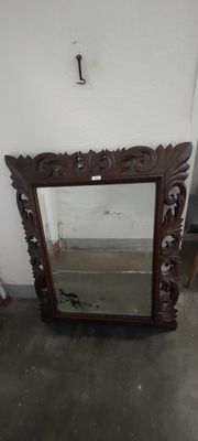 a mirror that is sitting on the floor next to a chair