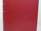 a red book sitting on top of a table next to a white wall