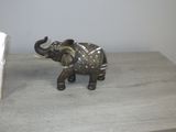 une statue d'éléphant posée sur une table, à côté d'un panneau