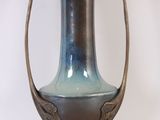 a blue and brown vase sitting on a white surface