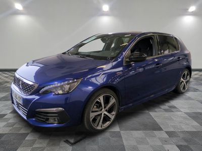 la voiture bleue est garée sur un sol en damier dans le garage