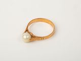 a close up of a gold ring with a pearl on it