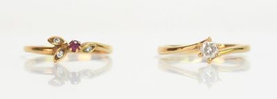 deux bagues en or ornées de pierres roses et blanches sur un fond blanc