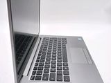 a silver laptop with a black keyboard on a white surface