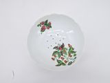 bowl with birds and flowers painted on it on a white surface