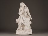 a statue of a woman sitting on a rock with a dog