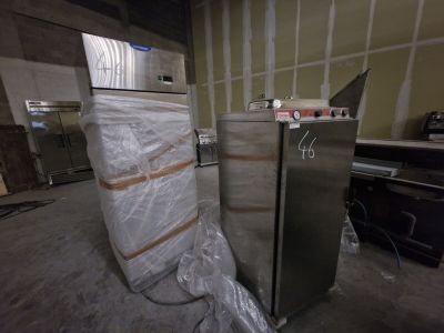 deux réfrigérateurs au milieu d'une pièce en cours de travaux
