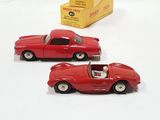 two toy cars sitting next to each other on a white surface