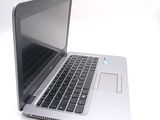 a silver laptop with a black keyboard on a white surface