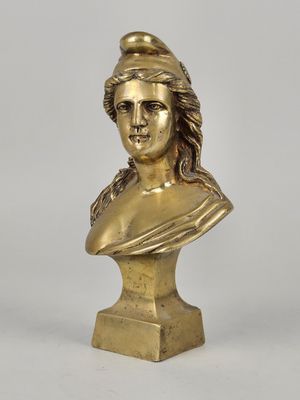 a gold bust of a woman with a hat on her head
